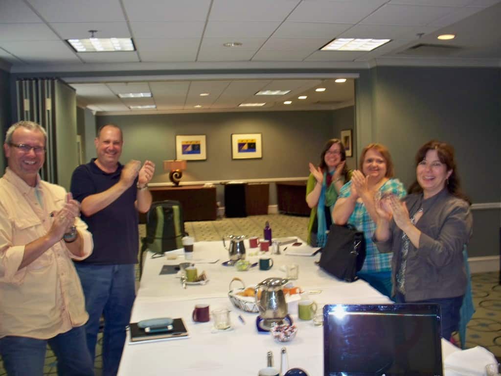 A group of writers from a retreat giving a standing ovation